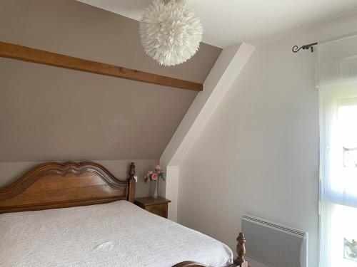 une chambre avec un lit et un lustre dans l'établissement Gite 4 - Maison la Vigneronne, à Mittelwihr