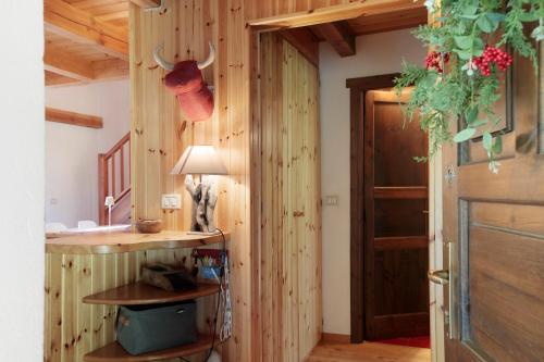 a room with a wooden wall with a door and a table at Casa Caterina La Thuile in La Thuile