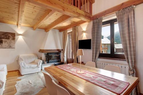 a dining room with a table and a fireplace at Casa Caterina La Thuile in La Thuile