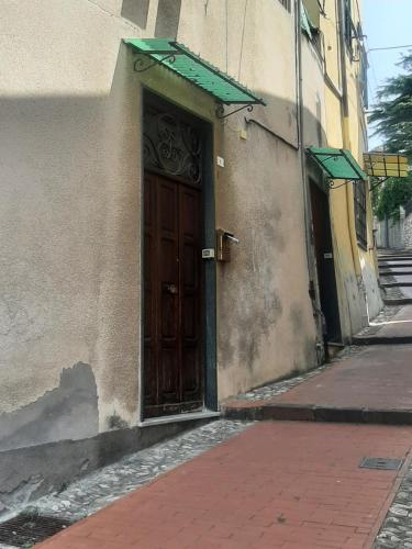 a building with a wooden door on a street at La stanza di Dalila in Imperia