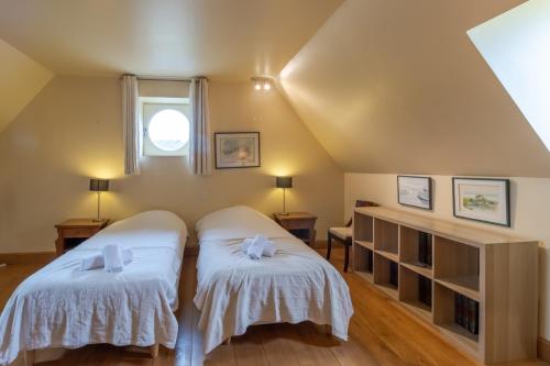 a attic bedroom with two beds and a window at Demeure Au Coeur De La Nature in Domme