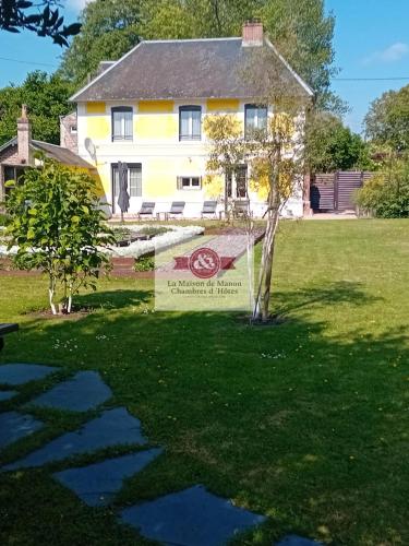 une maison avec un panneau devant dans l'établissement La Maison de Manon Calvados Chambres D'hôtes, à Bonnebosq