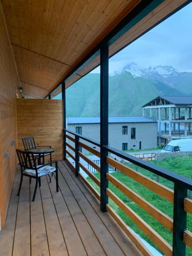 a wooden balcony with a table and a chair on it at Mountain View in Stepantsminda