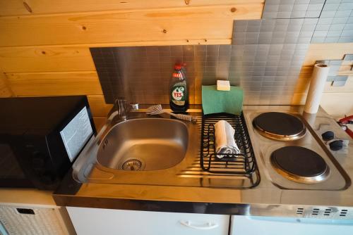 a kitchen counter with a sink and a microwave at Cosy Cabin in Hallstahammar