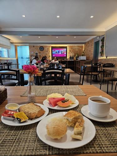 a table with plates of food and a cup of coffee at Blue Inn Hotel in Boa Vista