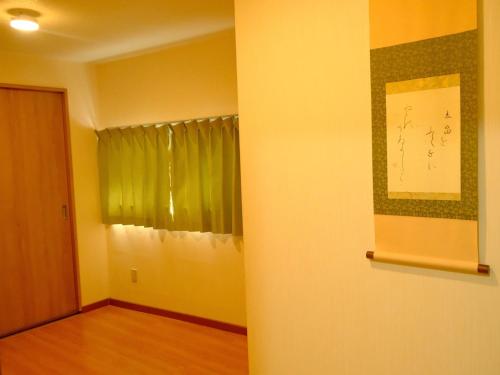an empty room with a window and a curtain at 一间民宿 in Wada