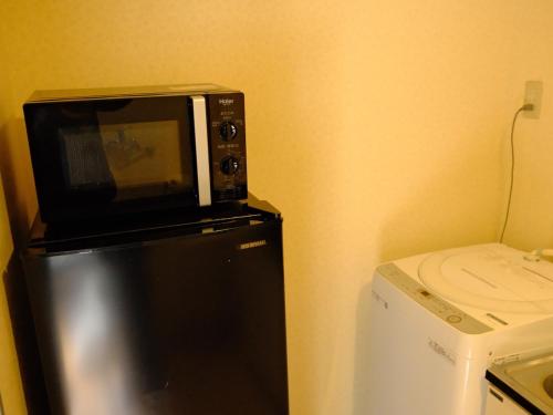 a microwave sitting on top of a refrigerator at 一间民宿 in Wada