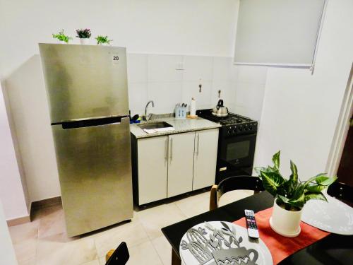 a kitchen with a stainless steel refrigerator and a table at Hermoso Departamento en Vicente lopez in Vicente López