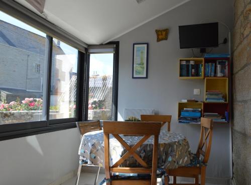 a room with a table and chairs and a window at PentyTy TadKozh Très proche du port de Kérity in Penmarcʼh