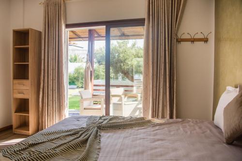 a bedroom with a bed and a large window at Dar Lina "Charme et nature" in El Haouaria