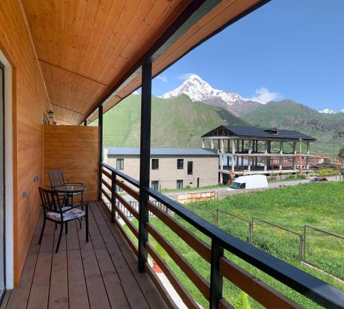 a balcony with a table and a view of mountains at Mountain View in Stepantsminda