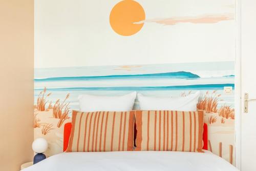 - une chambre avec un lit orné d'une peinture sur la plage dans l'établissement Joli 2 pièces dans un beau quartier de Paris-II, à Paris