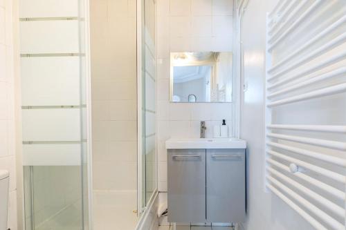 une salle de bain avec un lavabo et un miroir dans l'établissement Joli 2 pièces dans un beau quartier de Paris-II, à Paris
