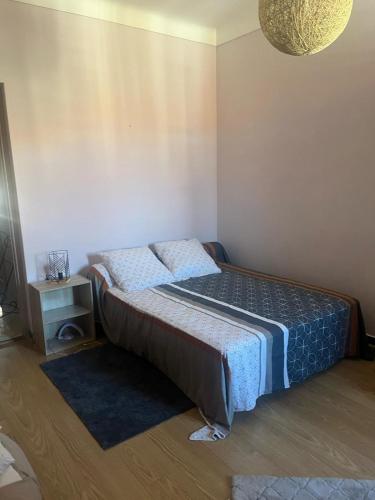 une petite chambre avec un lit et une table de chevet dans l'établissement Appartement Centre-Ville Propriano, à Propriano