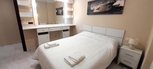 a bedroom with a white bed and a sink at EnViveiro Casco Histórico in Viveiro