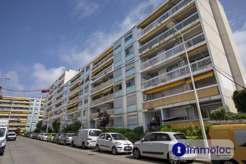 une rangée de voitures garées devant un bâtiment dans l'établissement Studio near airport, à Nice