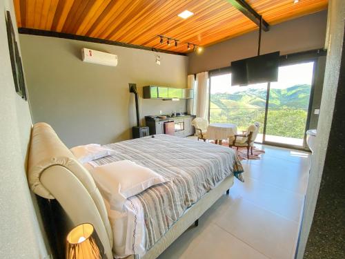 a bedroom with a bed and a table and chairs at Villa Mantiqueira SFX - Cabanas in São José dos Campos
