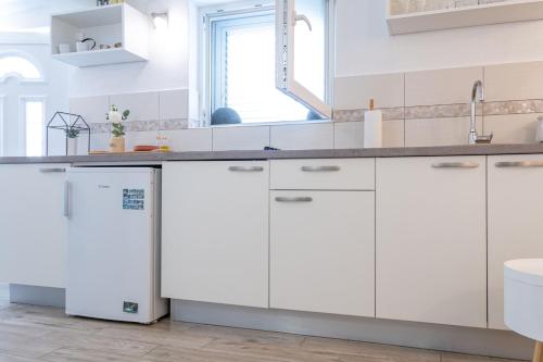 a kitchen with white cabinets and a sink at Apartment Ban in Šibenik