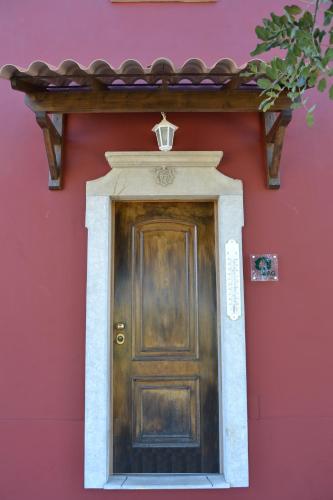 a wooden door on a red building with a pink wall at Villa Monte da Alfarrobeira in Estói