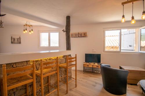 - un salon avec un bar et une télévision dans l'établissement Villa Solsticia, à Albitreccia