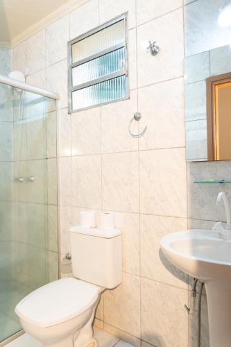 a bathroom with a toilet and a shower and a sink at Hotel Estancia Santa Amélia in Jabuticabal