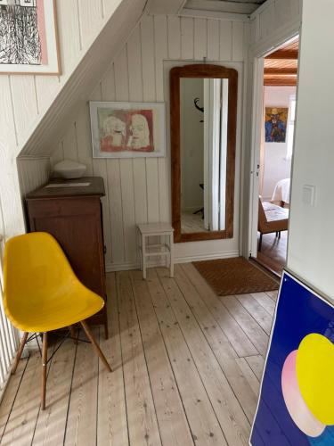 a room with a yellow chair and a mirror at Sølyst in Silkeborg