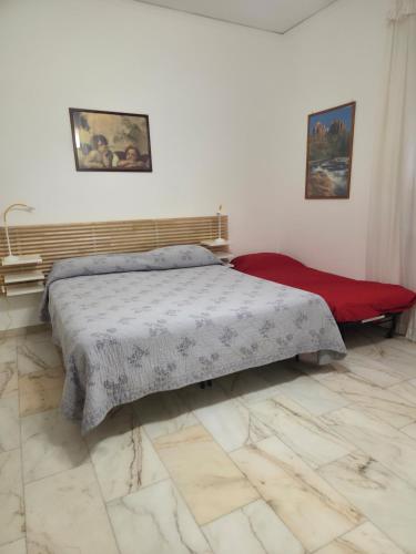 a bedroom with a bed and a red blanket at Metis Apartments Bellizzi in Bellizzi