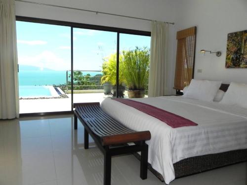 Una habitación con cama y vistas al océano. en Secluded Villa with Private Pool and Breathtaking Sea Views, en Ban Thong Phlu