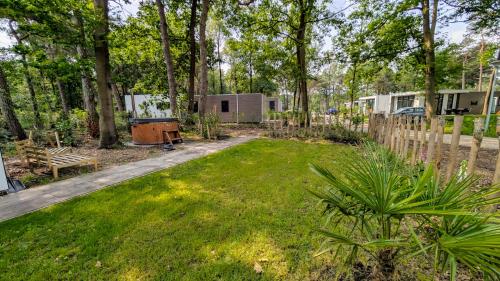 a yard with a fence and a trailer at Boslodge Het Groene Hert met Hottub in Haarle