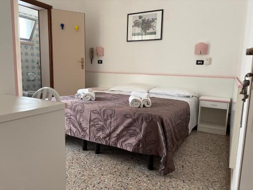 a bedroom with a bed with two towels on it at Hotel Rosy in Rimini