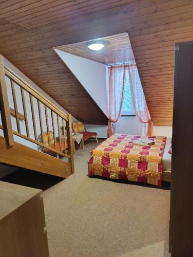 a attic room with a bed and a staircase at Penzion SIESTA in Příbor