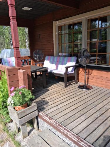 a wooden deck with a couch and a table at Lapikas in Kallo