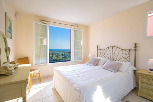 une chambre avec un lit blanc et une grande fenêtre dans l'établissement Villa Grande Vue by Villa Plus, à Biot