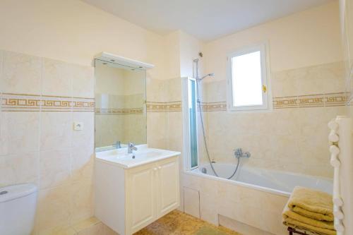 une salle de bain avec un lavabo, une baignoire et des toilettes dans l'établissement Villa Grande Vue by Villa Plus, à Biot