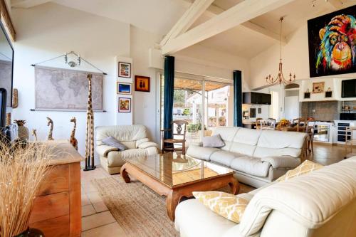 a living room with couches and a table at Villa Harmonie by Villa Plus in Flassans-sur-Issole