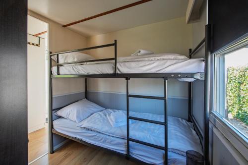 two bunk beds in a room with a window at 27, Beekse Bergen, Efteling, Woods, Private Parking! in Oisterwijk