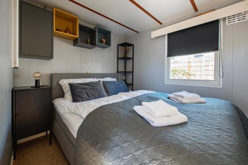 a bedroom with a large bed with towels on it at 27, Beekse Bergen, Efteling, Woods, Private Parking! in Oisterwijk