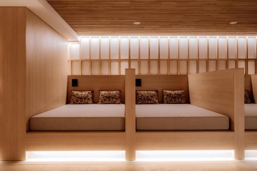 two beds in a room with lights on the wall at Hotel Auerhahn in Schluchsee