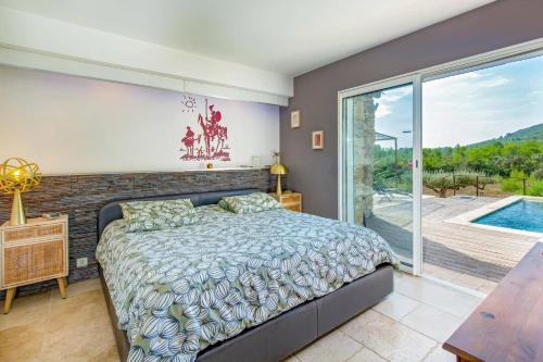 une chambre avec un lit et une grande fenêtre dans l'établissement Villa Les Bories by Villa Plus, au Cannet-des-Maures