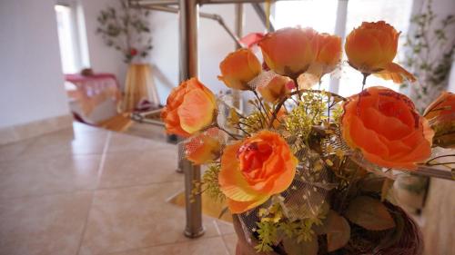 a vase filled with orange flowers in a room at Pamir Guest House in Shipkovo