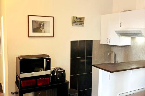 une cuisine avec un micro-ondes et un plan de travail dans l'établissement Pleasant apt wagram neighborhood, à Paris