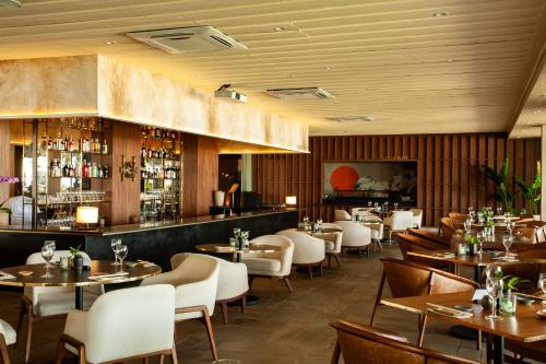 a restaurant with tables and chairs and a bar at Casa Grande Hotel Resort & Spa in Guarujá