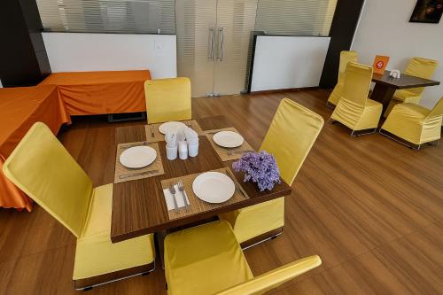 a dining room with a table and yellow chairs at Hotel Kian by JMD Group in New Delhi