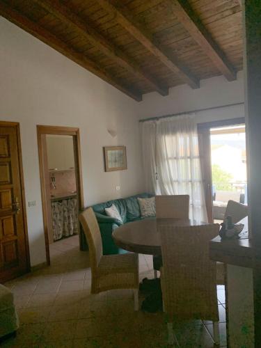 a living room with a table and a couch at Splendido appartamento San Teodoro centro in San Teodoro