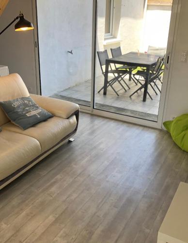 un salon avec un canapé et une table dans l'établissement Maison climatisée et Studio au calme à Royan, à Royan