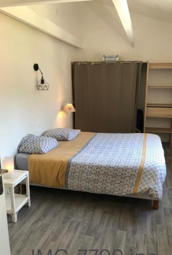 - une chambre avec un lit dans une pièce avec un placard dans l'établissement Maison climatisée et Studio au calme à Royan, à Royan