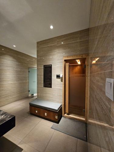 a bathroom with a bench in the middle of a room at Hegarmanah Residence Apartment in Bandung