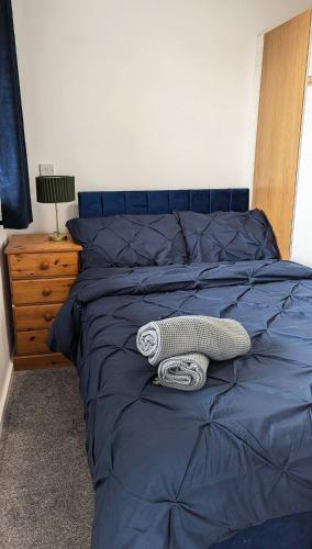 a bed with a blue comforter and a lamp on it at Quiet, Cozy Flat & Garden In Leafy Sheffield Area in Wincobank
