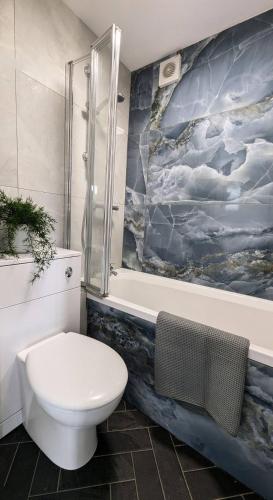 a bathroom with a toilet and a bath tub at Quiet, Cozy Flat & Garden In Leafy Sheffield Area in Wincobank