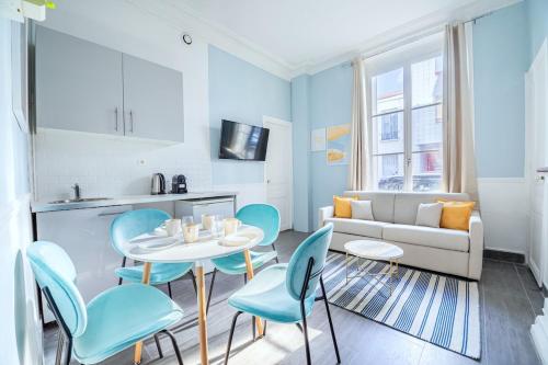 un salon avec une table, des chaises et un canapé dans l'établissement Appartement coloré 14ème arrondissement- IV, à Paris